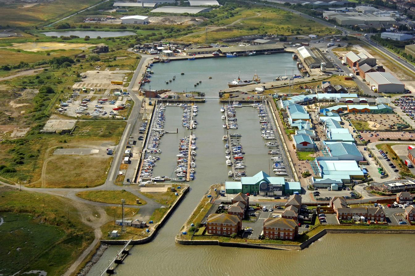 Aerial view of Fleetwood marina in Wyre Dock, looking up the entrance channel from the river past the lock towards the pontoons and the commercial dock beyond
